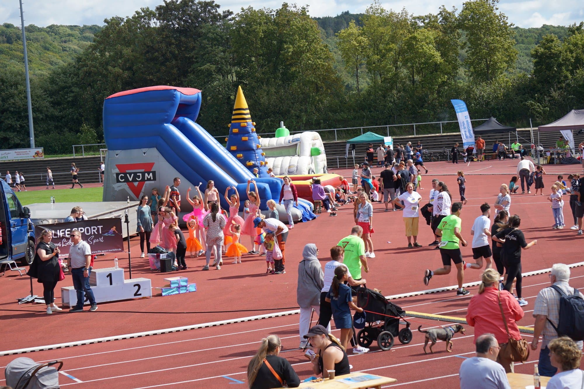 LebensLAUF Iserlohn im Leichtathletikstadion Hemberg — Menschen beim Laufen, Hüpfburgen, Stimmung